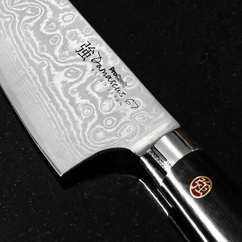 Close up image of ProCook Damascus 67 Chefs Knife showing Damascus steel's wavy and mottled design
