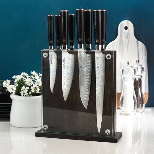 Image of a ProCook Damascus 67 knife set of eight displayed in a magnetic glass block on a kitchen worktop