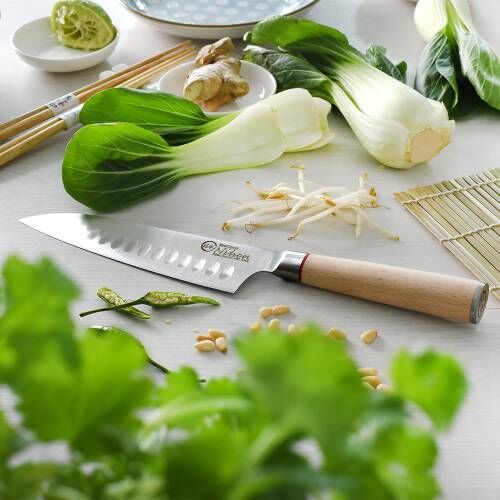 Image of a ProCook Nihon X50 santoku knife next to bok choi, beanshoots, ginger and green chillies